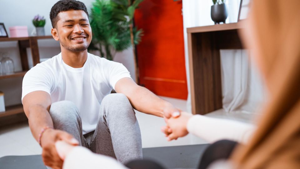 A smiling man holding hands with a woman